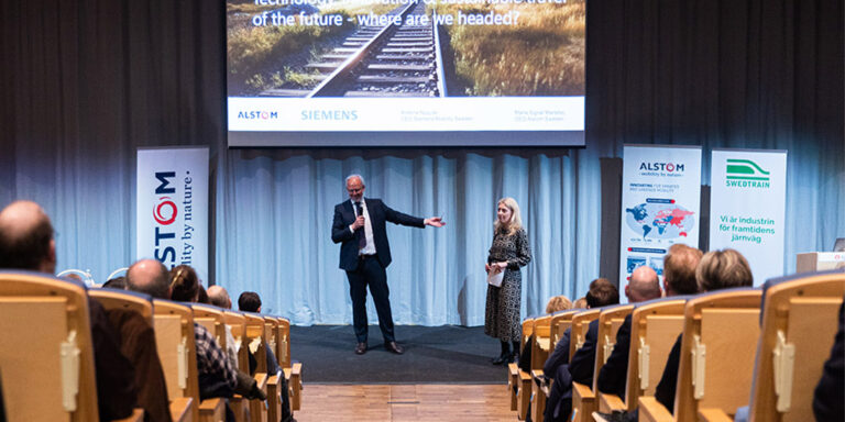 A man and a woman giving a lecture on stage