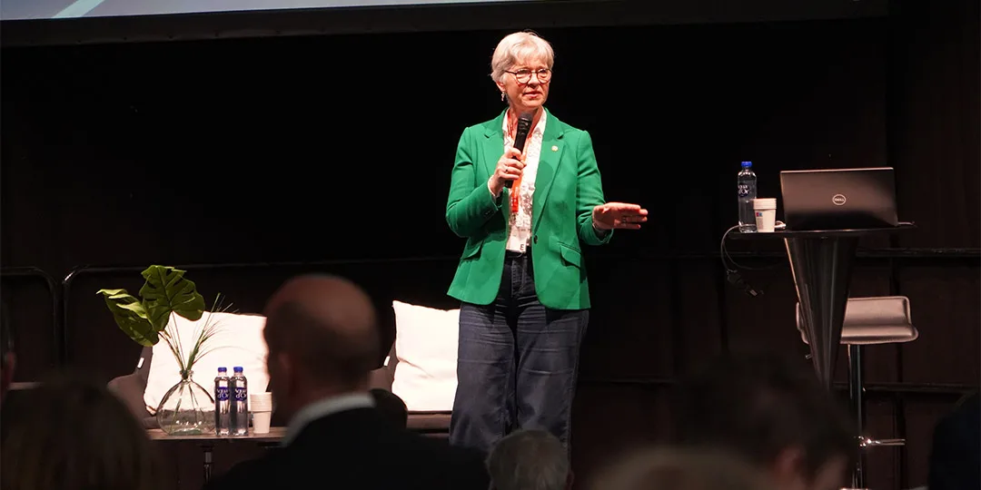 Seminarieprogram Människor som lyssnar på en man som demonstrerar i sin monter